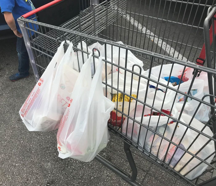 Most metal shopping carts in the U.S. have round notches in the frame that you can use to hang bags of groceries outside the cart.