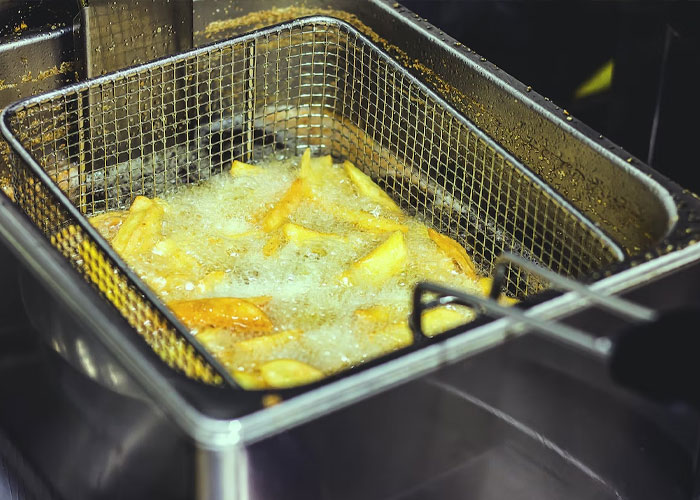 At KFC, we were supposed to change the fryer oil every couple days. Our penny-pinching manager had us change it every couple weeks. We'd just skim off the 'floaters' and cover it at night.