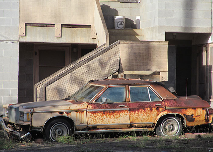 Really worn old beat-up cars right next to brand new extremely expensive cars.