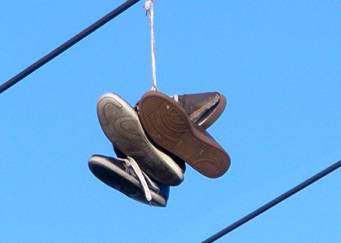 depends where u are because i think it might be a regional thing, but shoes hung up on power lines