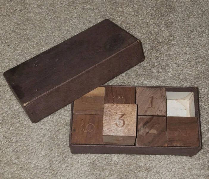 “6 numbered wooden cubes in a very old cardboard box”

"It’s an old puzzle called Octo-mania."