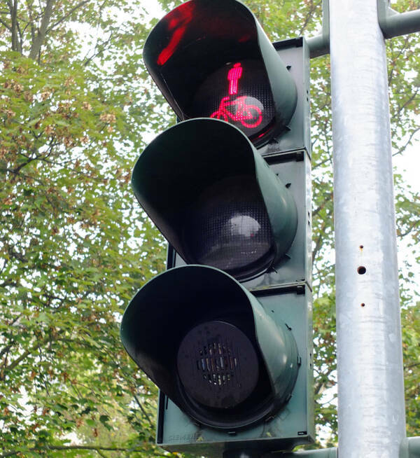 "What’s the bottom segment of this pedestrian stoplight in Germany?"

“I believe it’s a speaker giving a sound signal for blind people to let them know they can cross.”