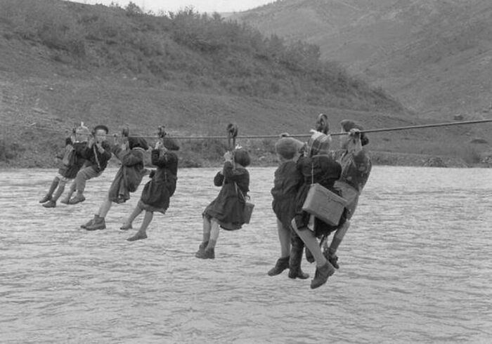 fascinating historical photographs - children cross the river using pulleys on their way to school 1959 italy