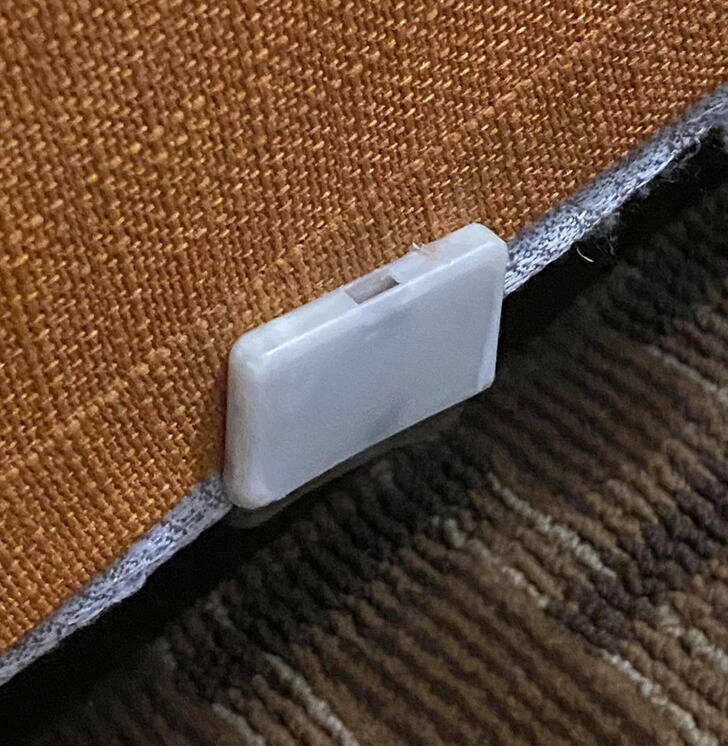 ’’What are these small white boxes around the base of our bed at the hotel?’’

’’I would of guess that they lock the cover onto the box spring. Slipping a screwdriver in the slot might release the cover. Much like those security pins on clothes, but in this case just a safety pin.’’