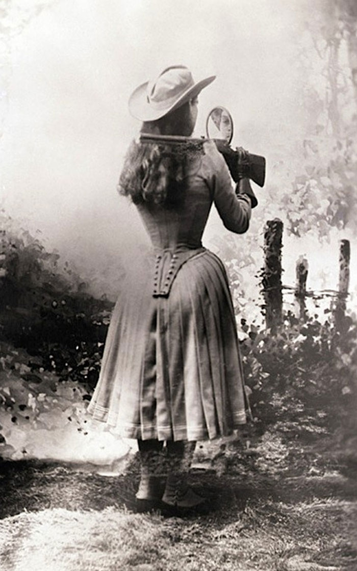 historical photographs - Annie Oakley Shooting A Gun Over Her Shoulder Using A Hand Mirror, 1899