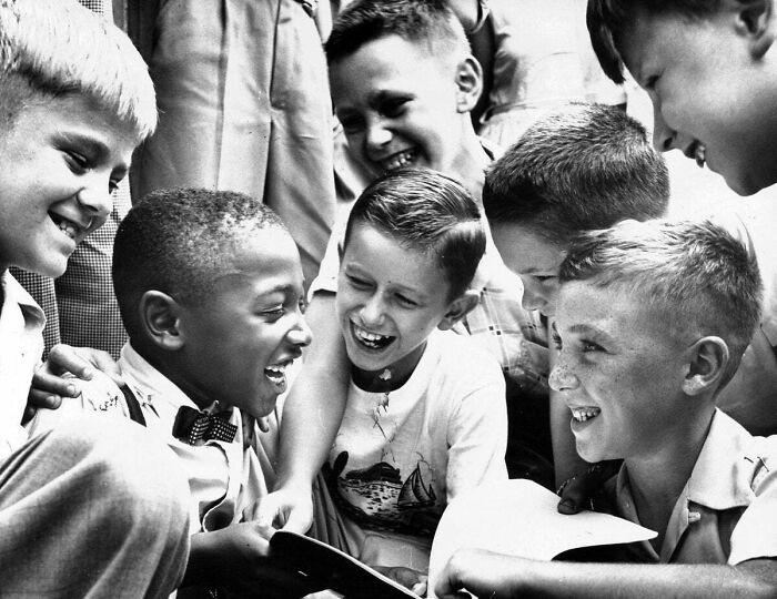 Charles Thompson being greeted by his new classmates, just 4 months earlier the Supreme Court ruled that racial segregation was unconstitutional. He was the only black child at the school. Sept 1954