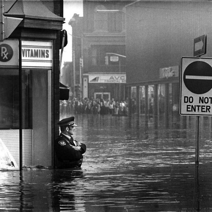 Police Officer Guarding A Pharmacy In High-Flood Waters, Ontario, 1974.