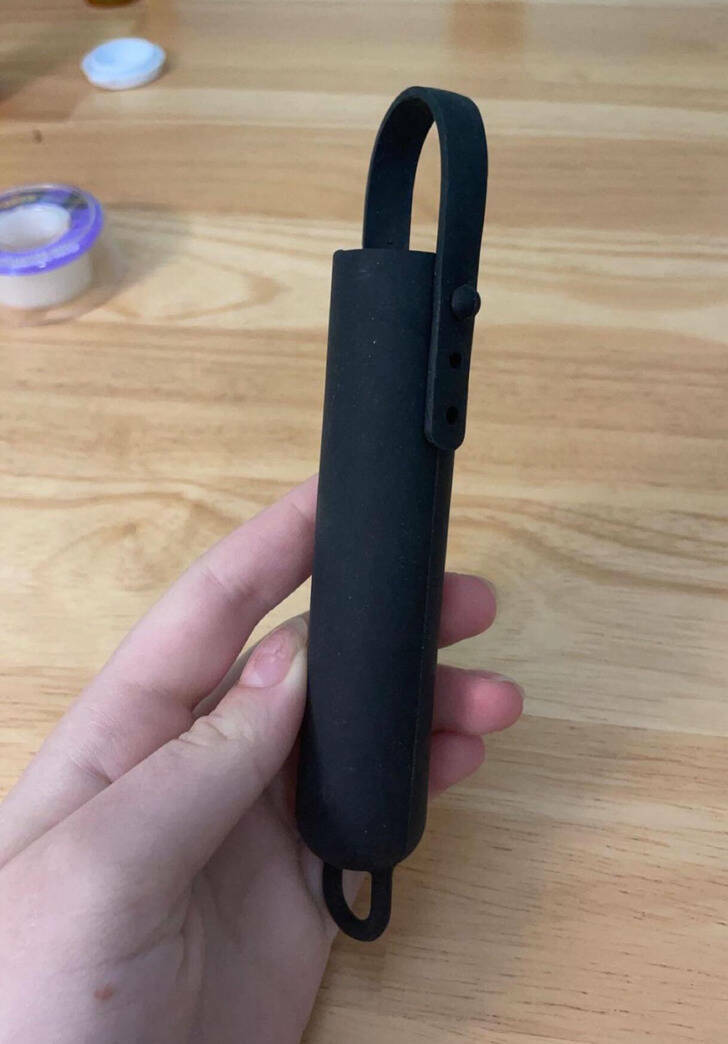 “Found in a junk drawer, we have no idea what it’s supposed to hold.”

“It’s a curling iron cover. The loop goes under the ‘arm’ of the curling iron.”