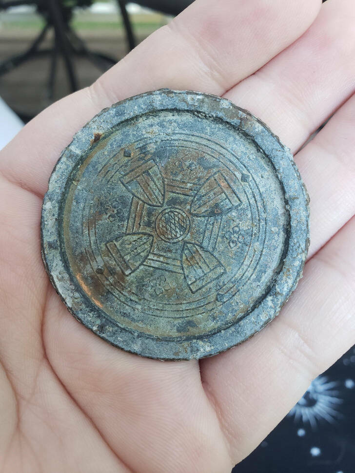 “My boyfriend found this in his backyard. It appears to be a medal of some sort? Theres nothing on the back of it.”

“Definitely a hub cap for a carriage wheel. The flange is at the surface of the hub, and the decorated area is pressed back in. Probably fell off a carriage at some point, and no one noticed.”