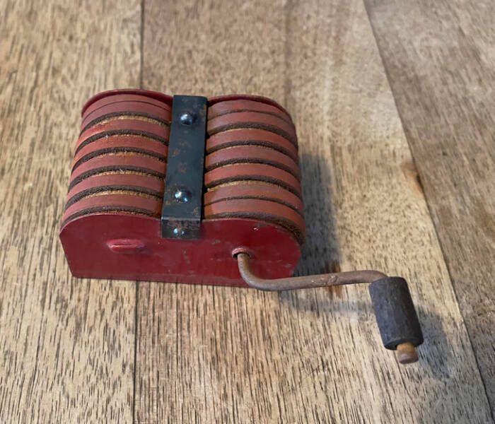 “2 small wooden spools wrapped with a leather strap. When you turn the handle, both spots spin.”

"Hand crank tool for safety razors."