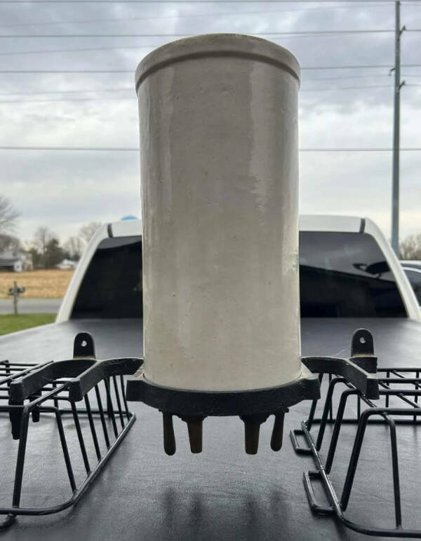 “Ceramic cylinder, approximately 15 inches tall, 6-inch diameter with 2 valves on the bottom and a cast iron mounting bracket.”

“It would appear to be a Lye jar for cleaning milking machine lines, but I can’t find how it works.”