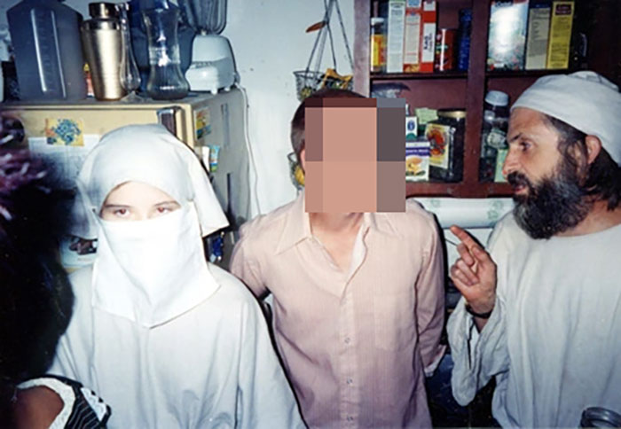 A girl in a veil at a party.
This pictureof Elizabeth Smart (far left) taken while she being was held captive by her kidnapper (pictured far right).Smart was missing for 9 months. the picture was taken some time in the middle of that period, at a party the kidnapper crashed with Smart. She was made to wear the veil in order to keep from being recognized in public