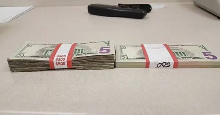 A stack of circulated $5 bills vs. new $5 bills: