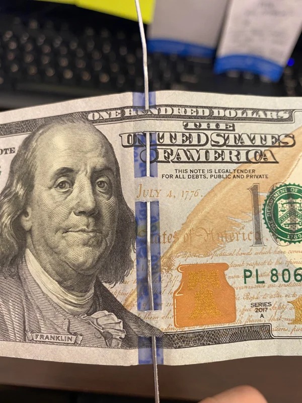 On the US $100 bills there are slits on the blue ribbon to deter counterfeits.