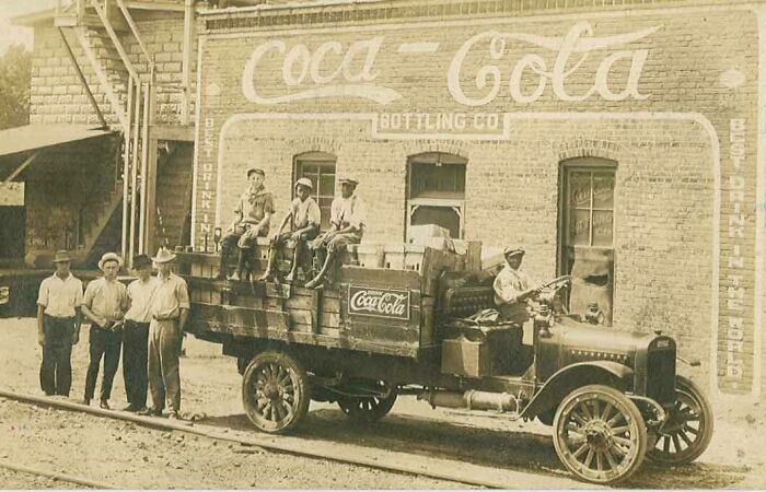 A Coca-Cola Delivery Truck With Three Young Boys Sitting On Side Of Truck, 1900