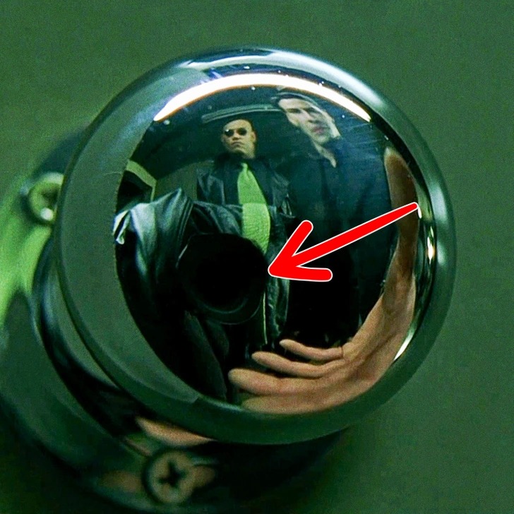 The Matrix. The camera is visible in the reflection of the doorknob in the scene. Despite the filmmakers’ attempts to conceal it, such as covering it with Morpheus’ jacket, attentive viewers noticed the mistake.