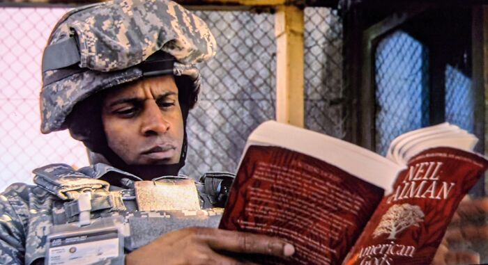 In The Good Omens TV Show, A Soldier At The Gate Is Reading American God's, Which Was Written By Neil Gaiman Who Also Co Wrote The Book Good Omens