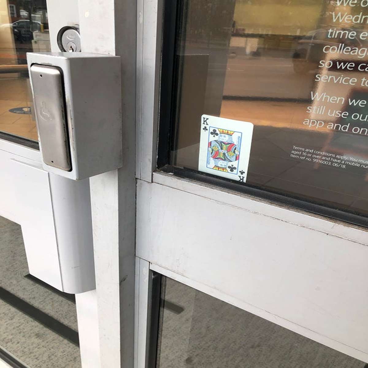 ”I’m waiting for the bank to open and they have this card facing the street. What is it used for?” Former bank employee here. It’s definitely a safety signal.

We switched ours quarterly and it is to let other employees know that it is all clear to open. Typically, we had two employees “open” the branch while the rest waited in the parking lot or across the street for “all clear.” The openers go in, turn off alarm, search the building, and check everything, then they set the signal.