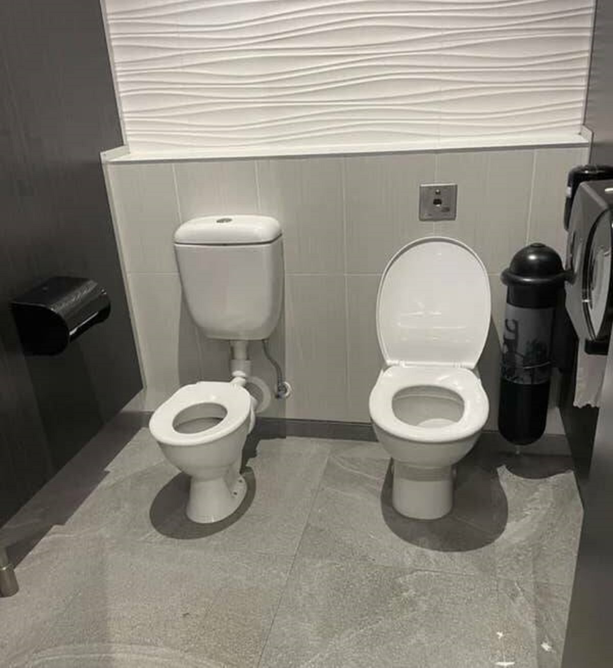 The Auckland airport in New Zealand has a child's toilet and an adult toilet in a single stall for parents.