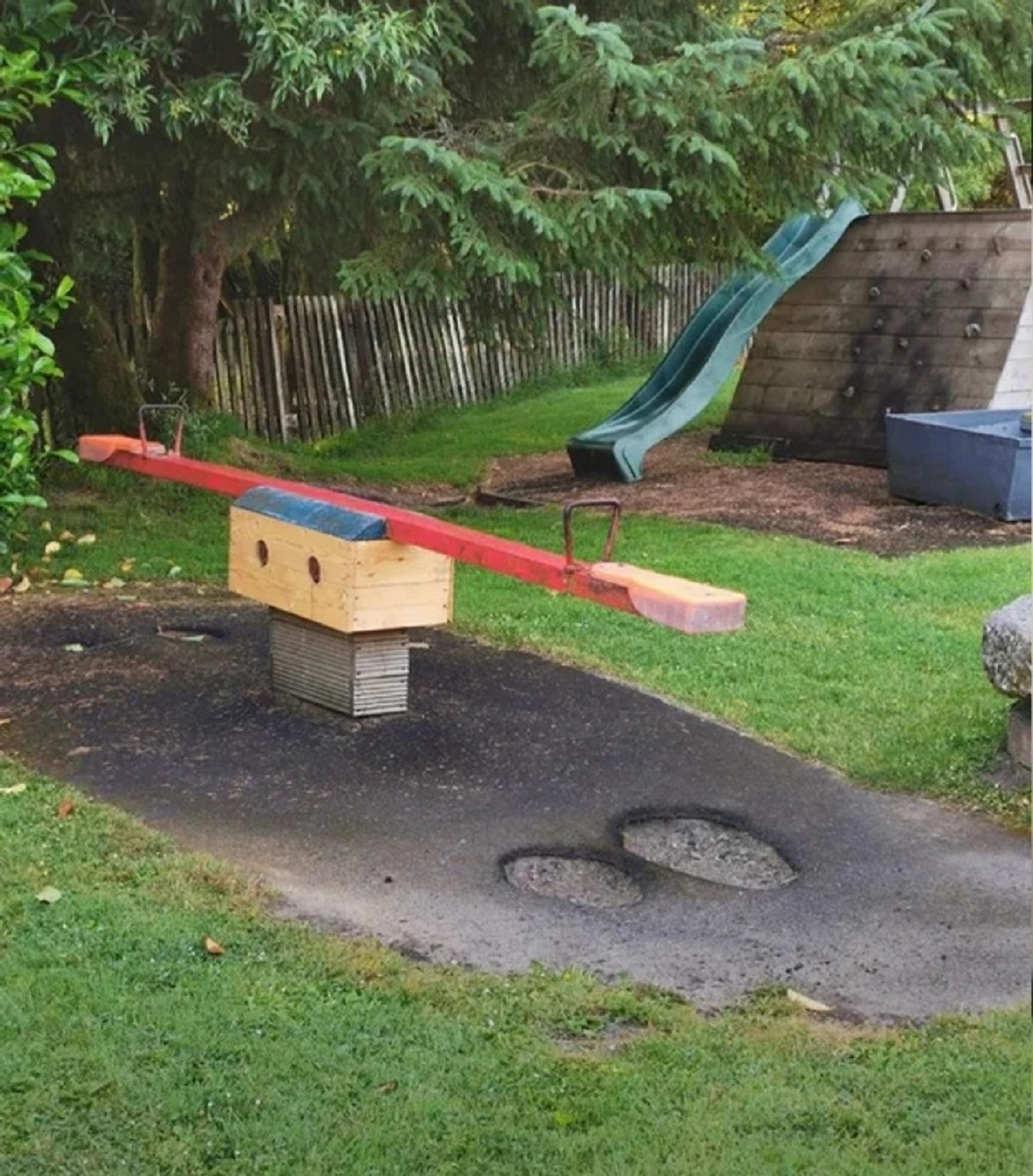 “A seesaw (teeter-totter) in my local playground where thousands of little feet have worn through the asphalt”