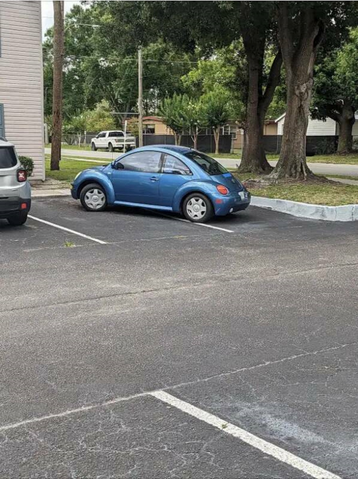 This person's neighbor parks their car diagonally across two parking spaces so that he and his wife don't miss out on the prime spots: