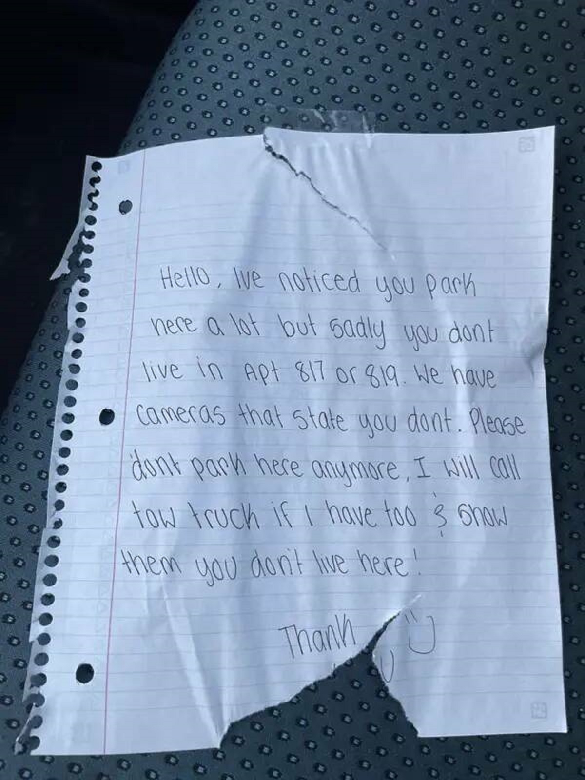 This person's neighbor left them a note, threatening legal action if they continue using the public parking in front of their home: