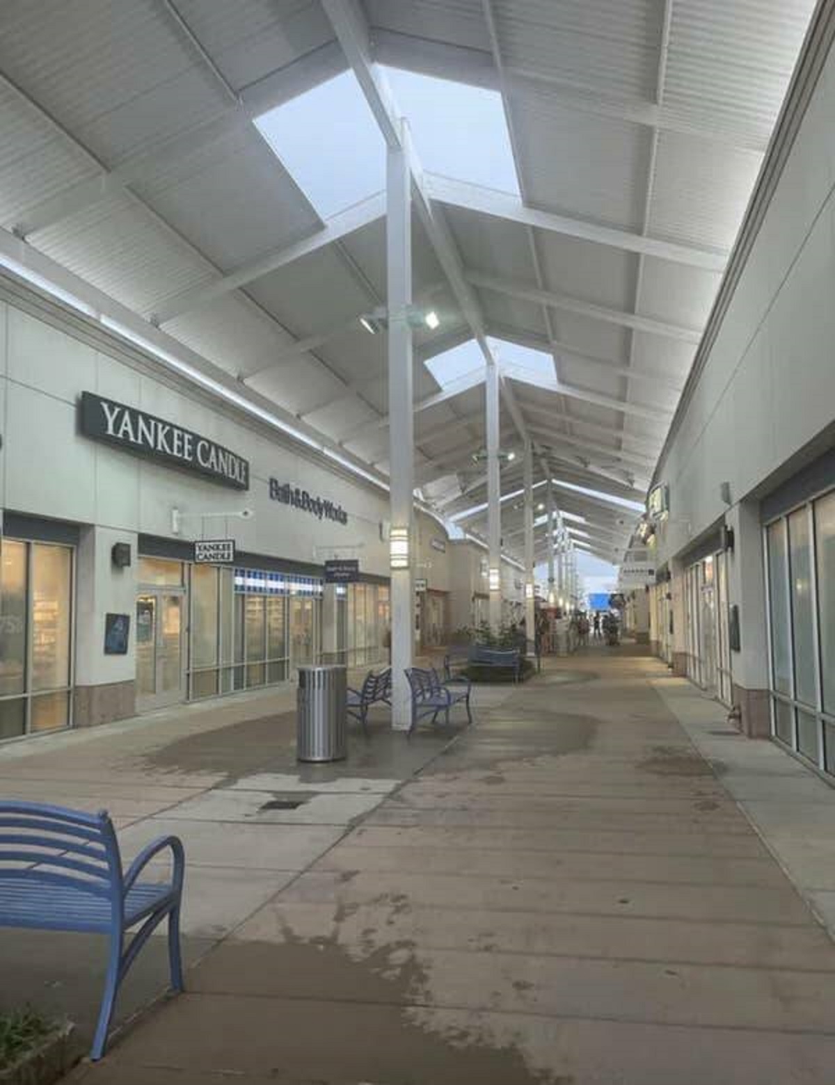 The designer of this open-air shopping center who put roofing over the whole thing EXCEPT the benches: