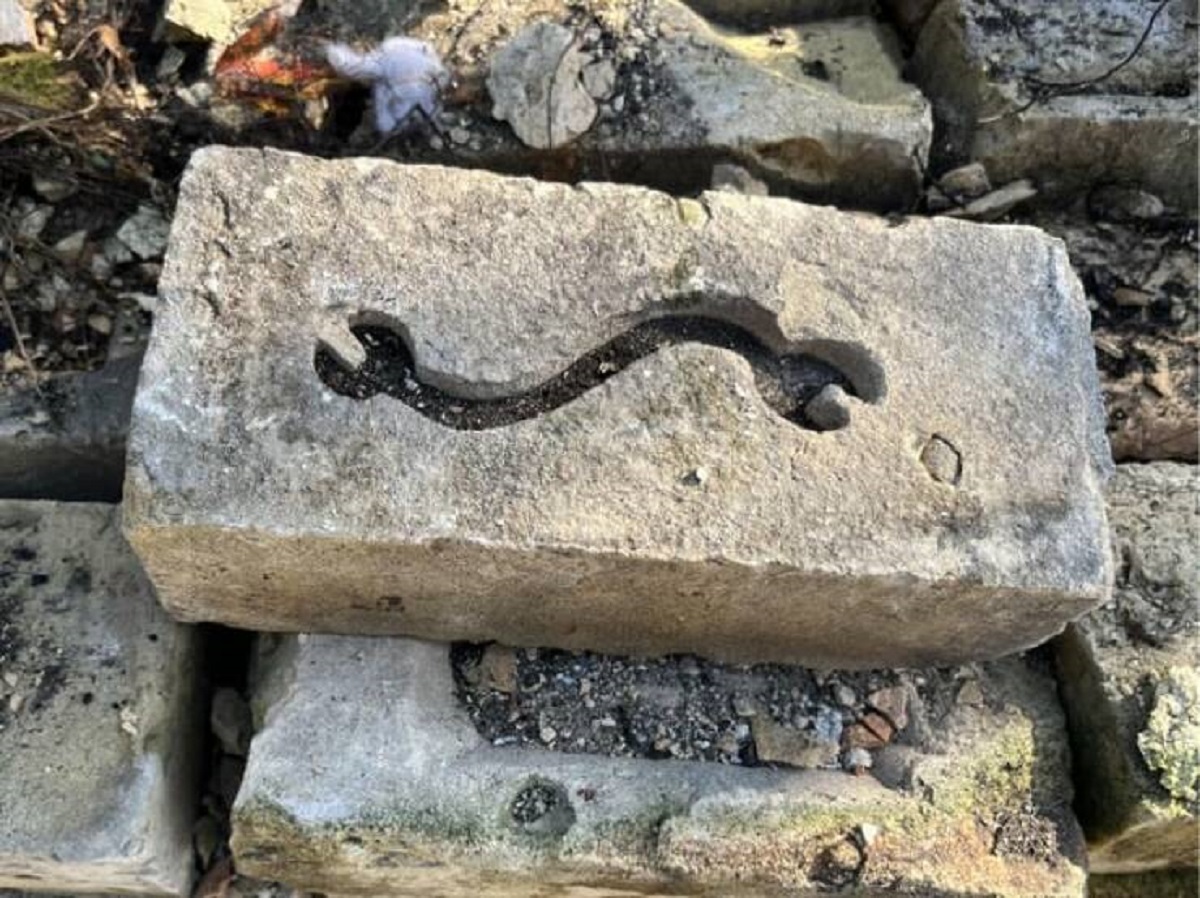 "This brick has a curvy wrench imprint in it"