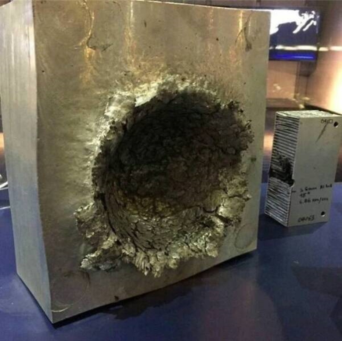 "Block Of Aluminum After It Was Hit By A 14-Gram Piece Of Plastic That Was Traveling 24,000 Feet Per Second (26,000 Kmph/16,000 Mph) In Space"