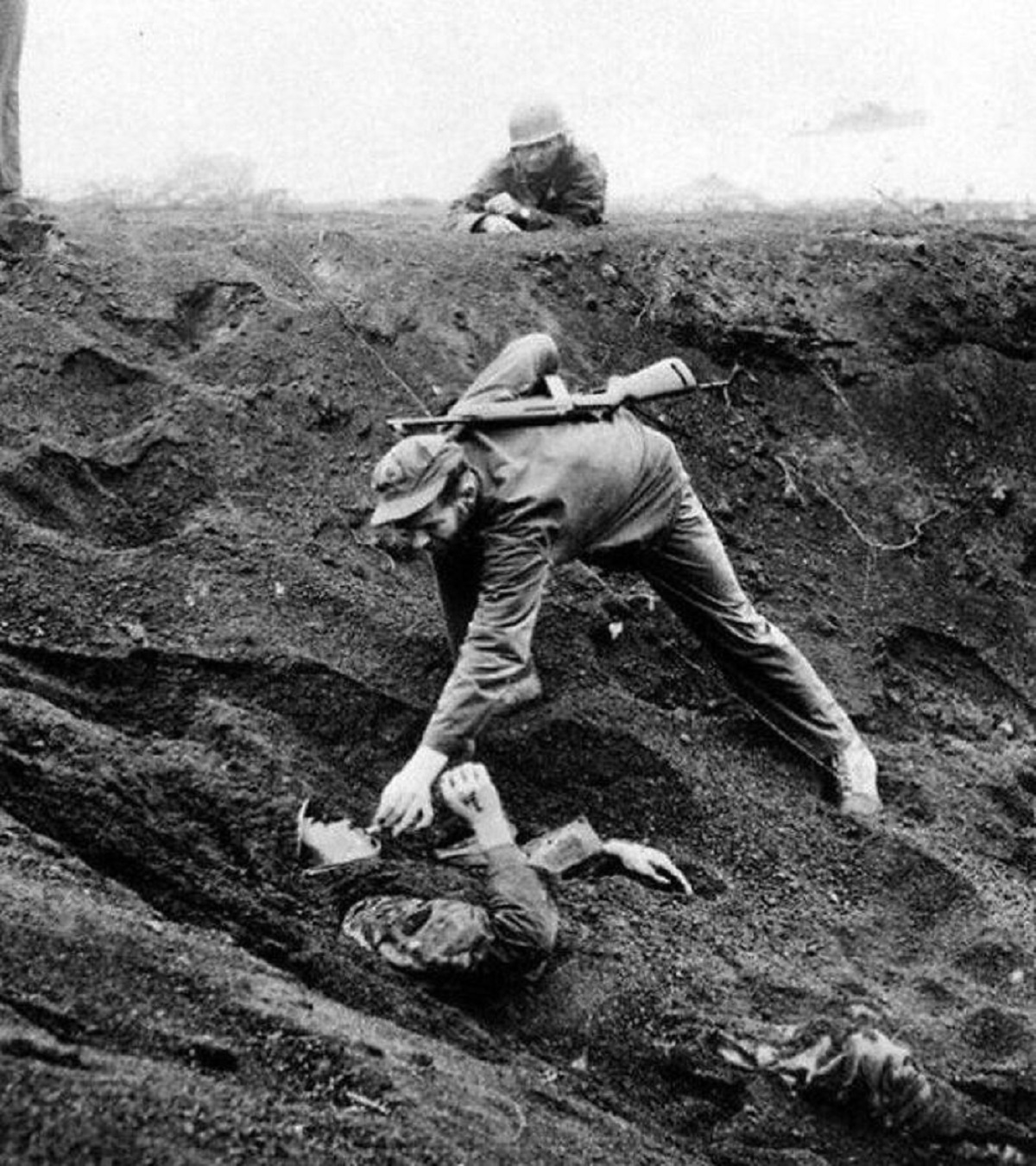 A U.S. marine gives a cigarette to an injured Japanese soldier, buried in the sand at the battle of Iwo Jima in 1945.