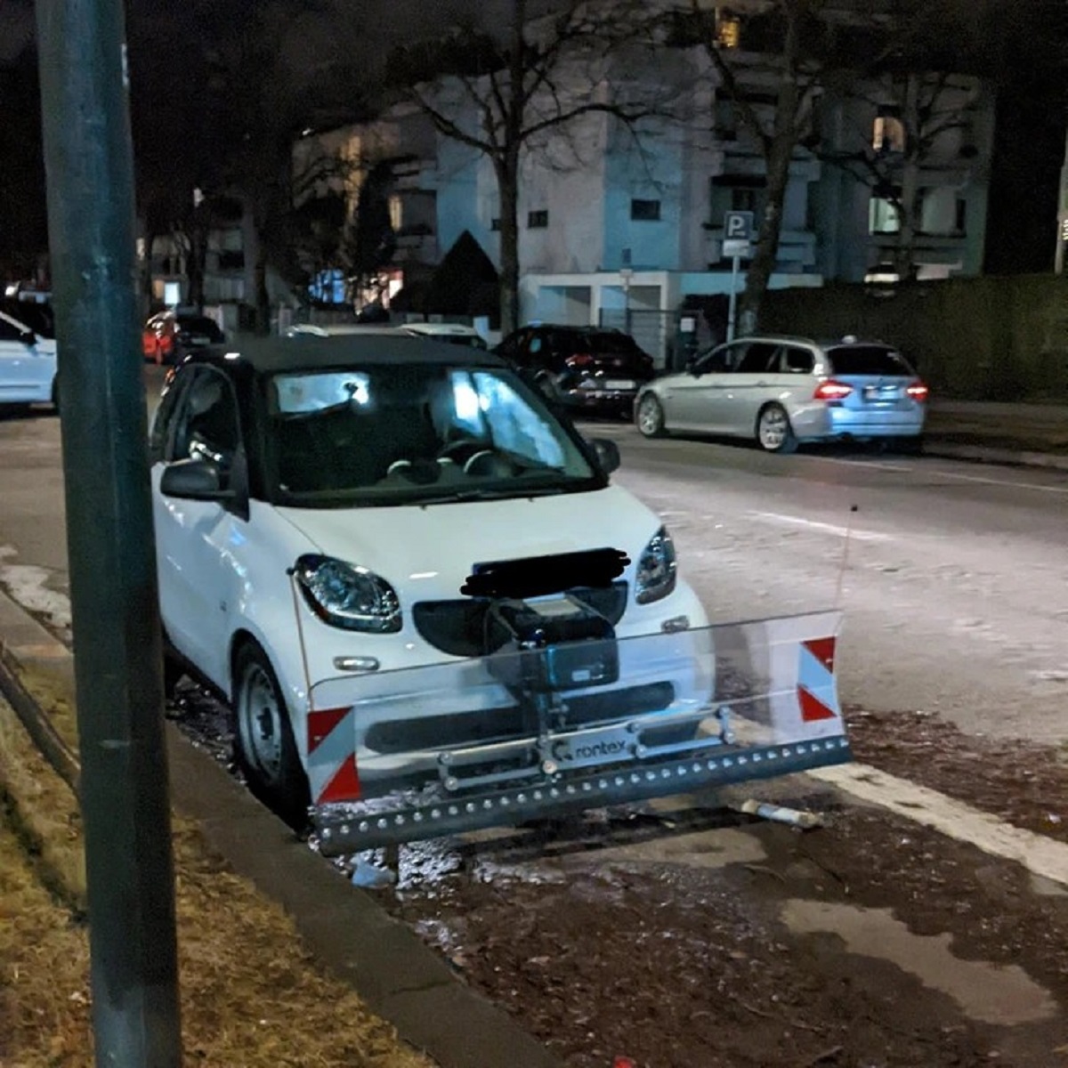 A smart car with a snowplow