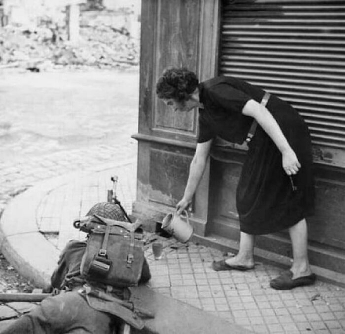 A French Civilian Woman Pours A Drink Of Cider For A British Soldier With Bren Machine Gun In Lisieux, 1944