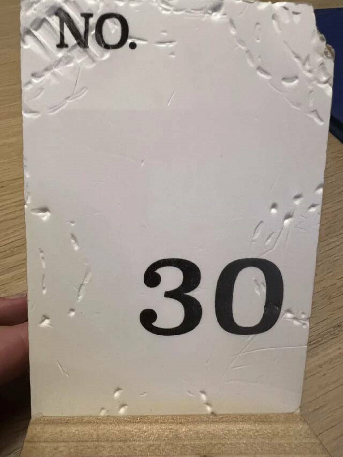 "The table number at the restaurant we are eating at is covered in bite marks"