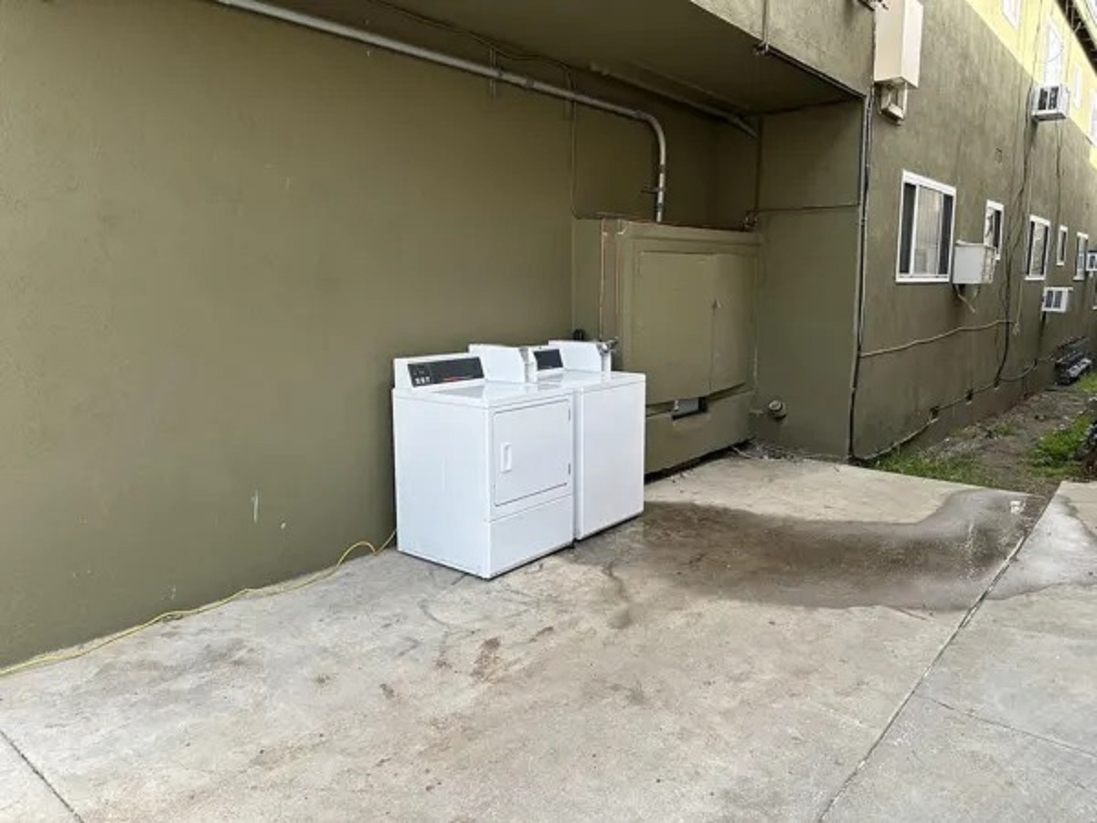 Landlord is converting the common areas (parking and laundry) into additional units. Introducing the new “open air” laundry room. Powered by an extension cord and water just runs out into the grass.