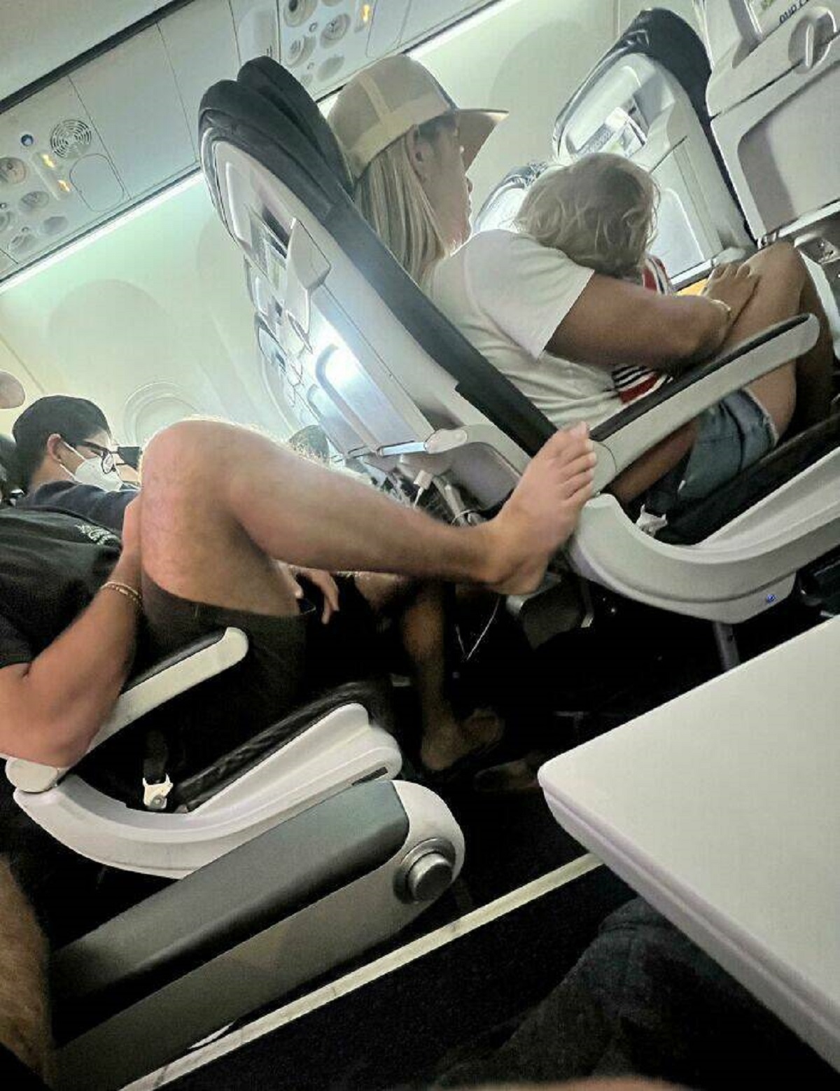 feet on plane armrest