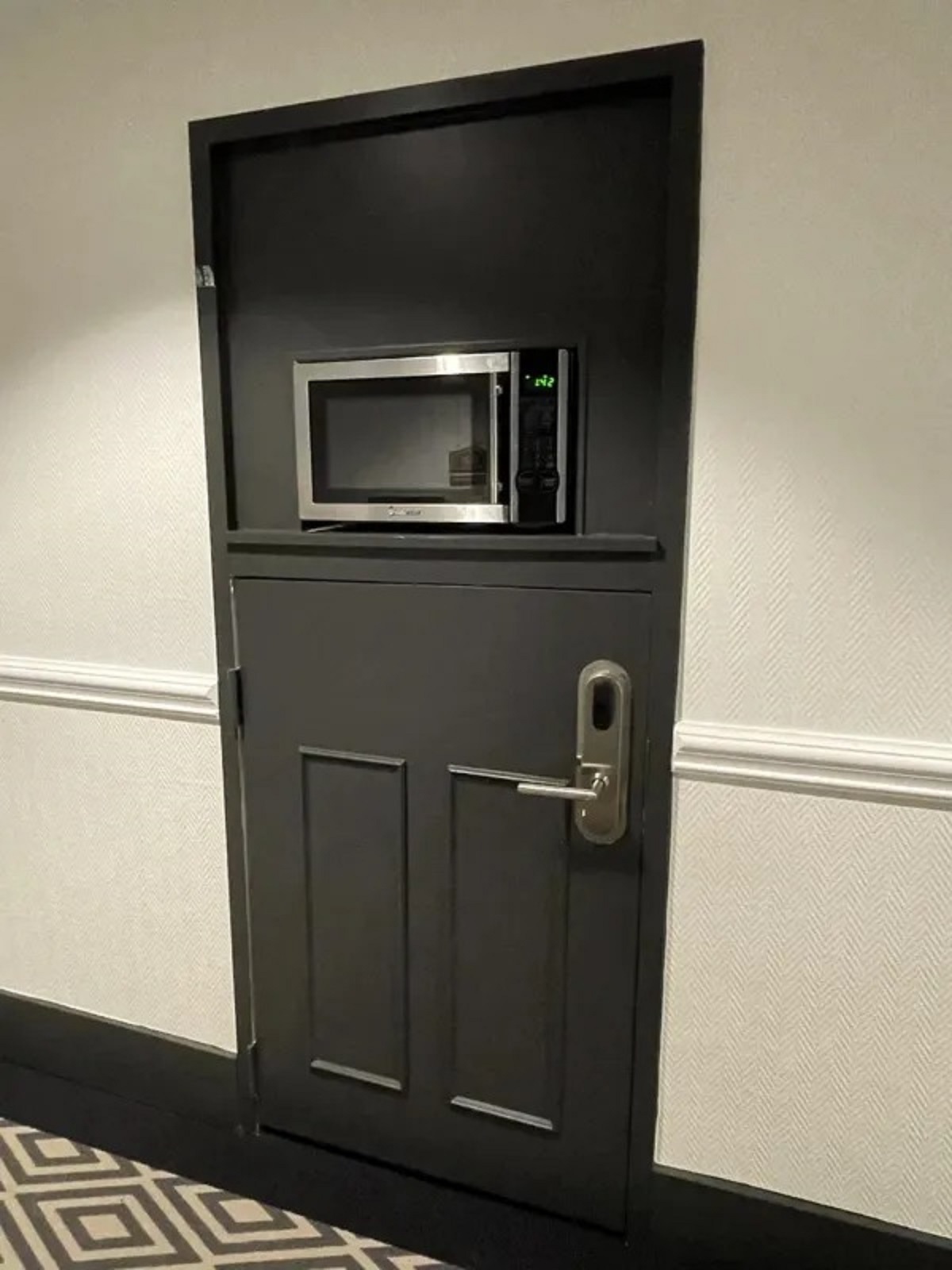 The hotel I’m staying at has one room door with a microwave mounted in it.