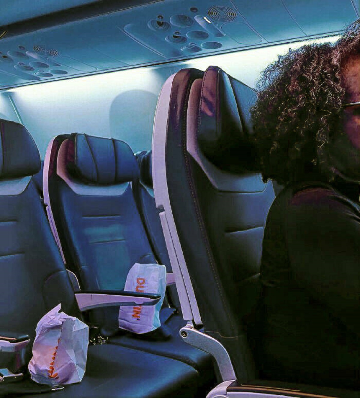"Woman Saving An Entire Row Of Plane Seats Behind Her With Donut Bags"