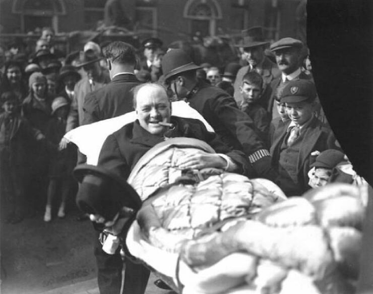 "Winston Churchill Is Carried From A Nursing Home Following Being Struck By A Car In New York City, 1931. He Was Crossing Fifth Avenue And Forgot That Cars Drove On The Opposite Side Of The Road From England, And Failed To Look To His Left"