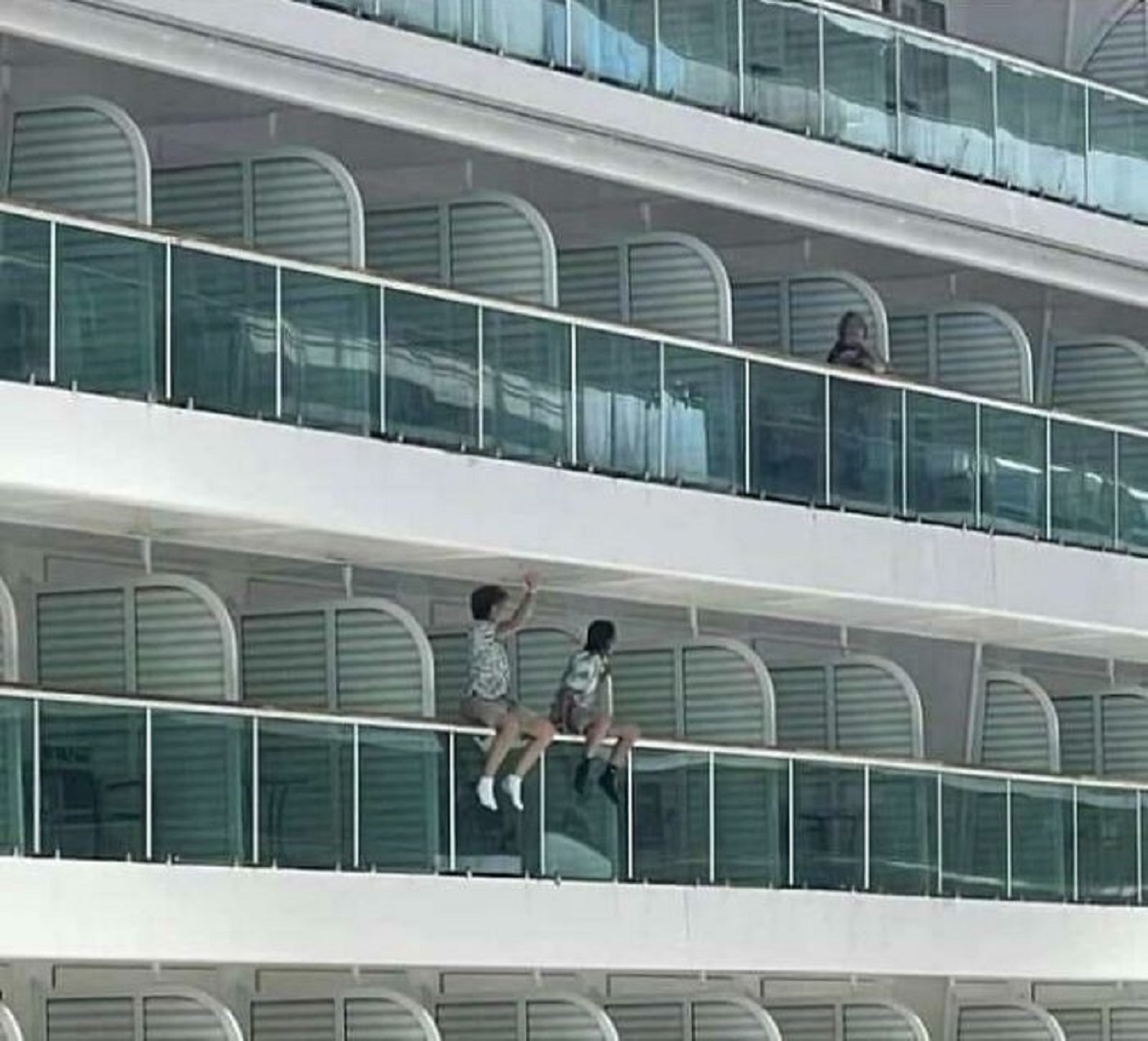 kids sitting on cruise ship balcony