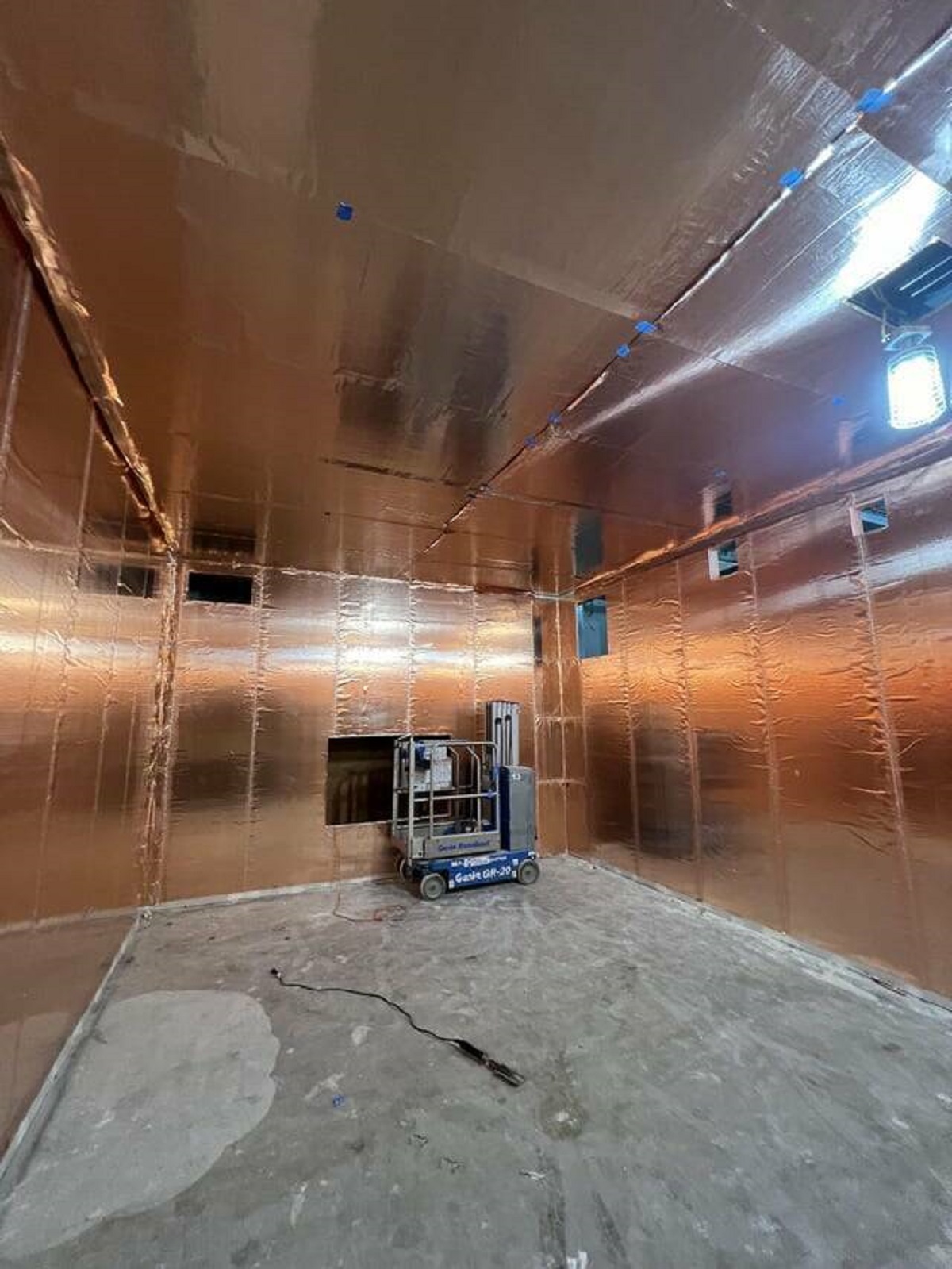 "An MRI room under construction, coated with copper wallpaper"
