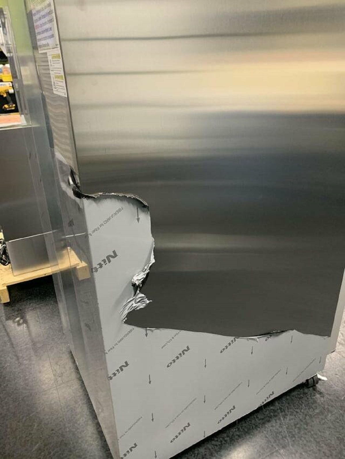 "It looks like the stainless steel is peeling off of this fridge at my work"