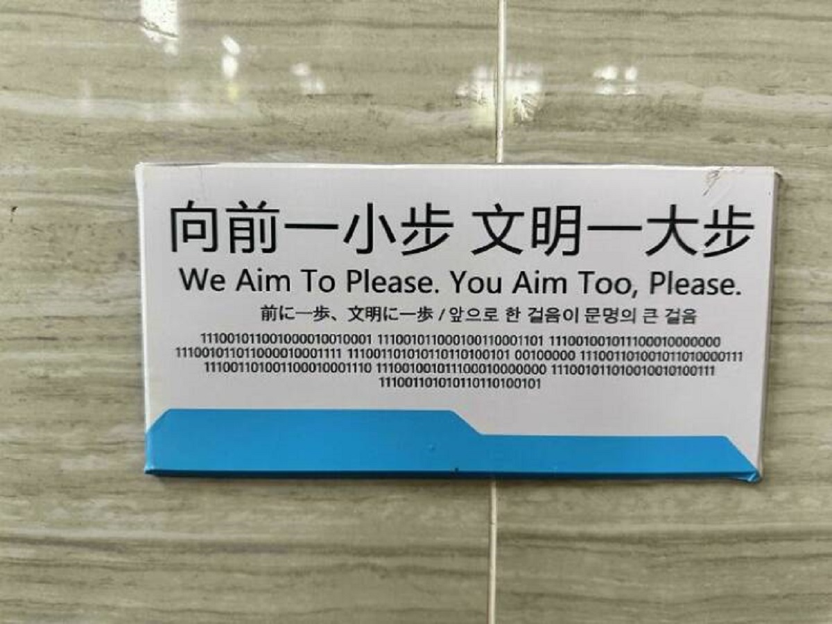"A Sign Over A Urinal In Chinese, English, Japanese, Korean And Binary"