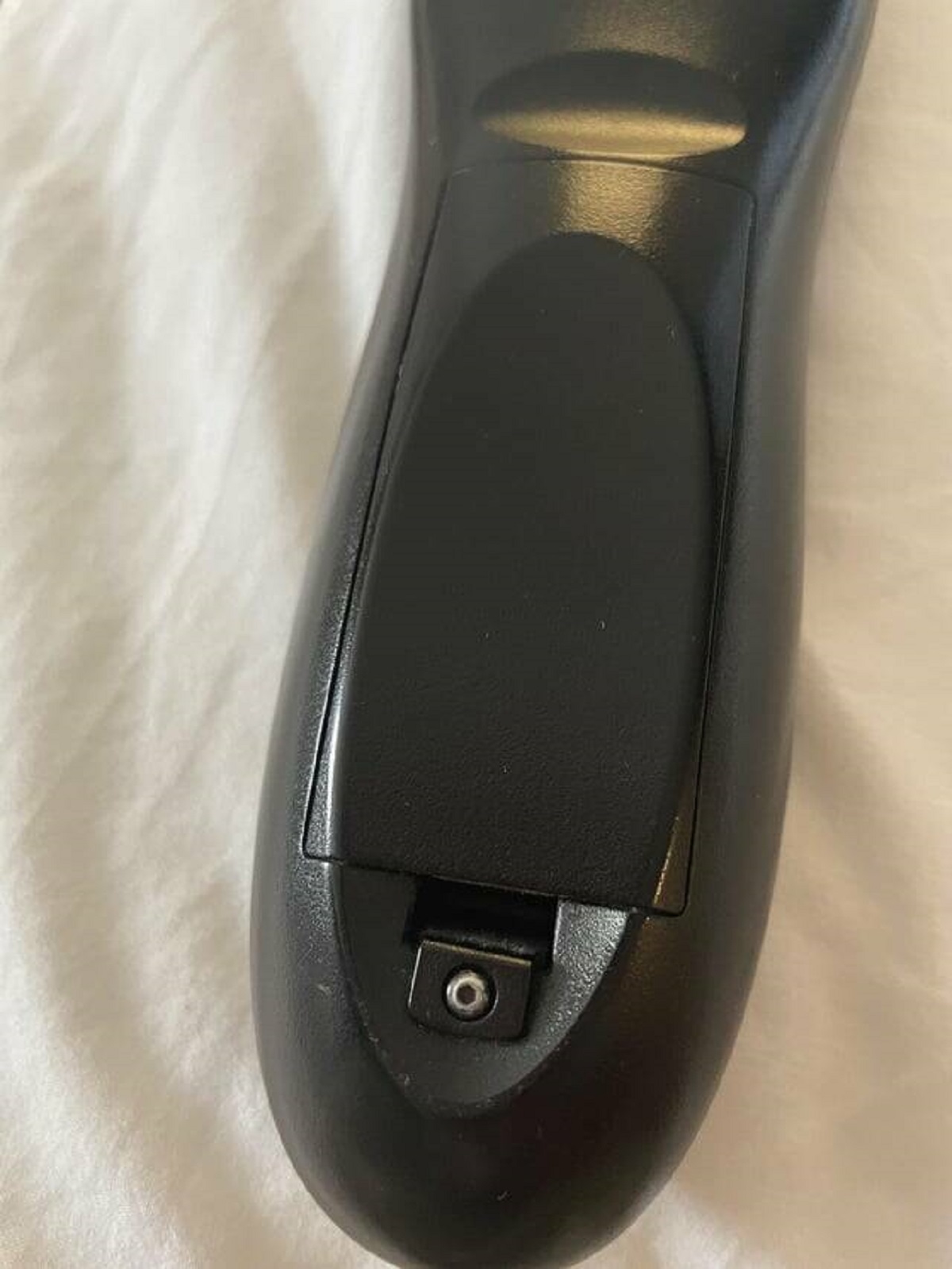 "Hotel TV remote has a hex screw locking the battery cover"