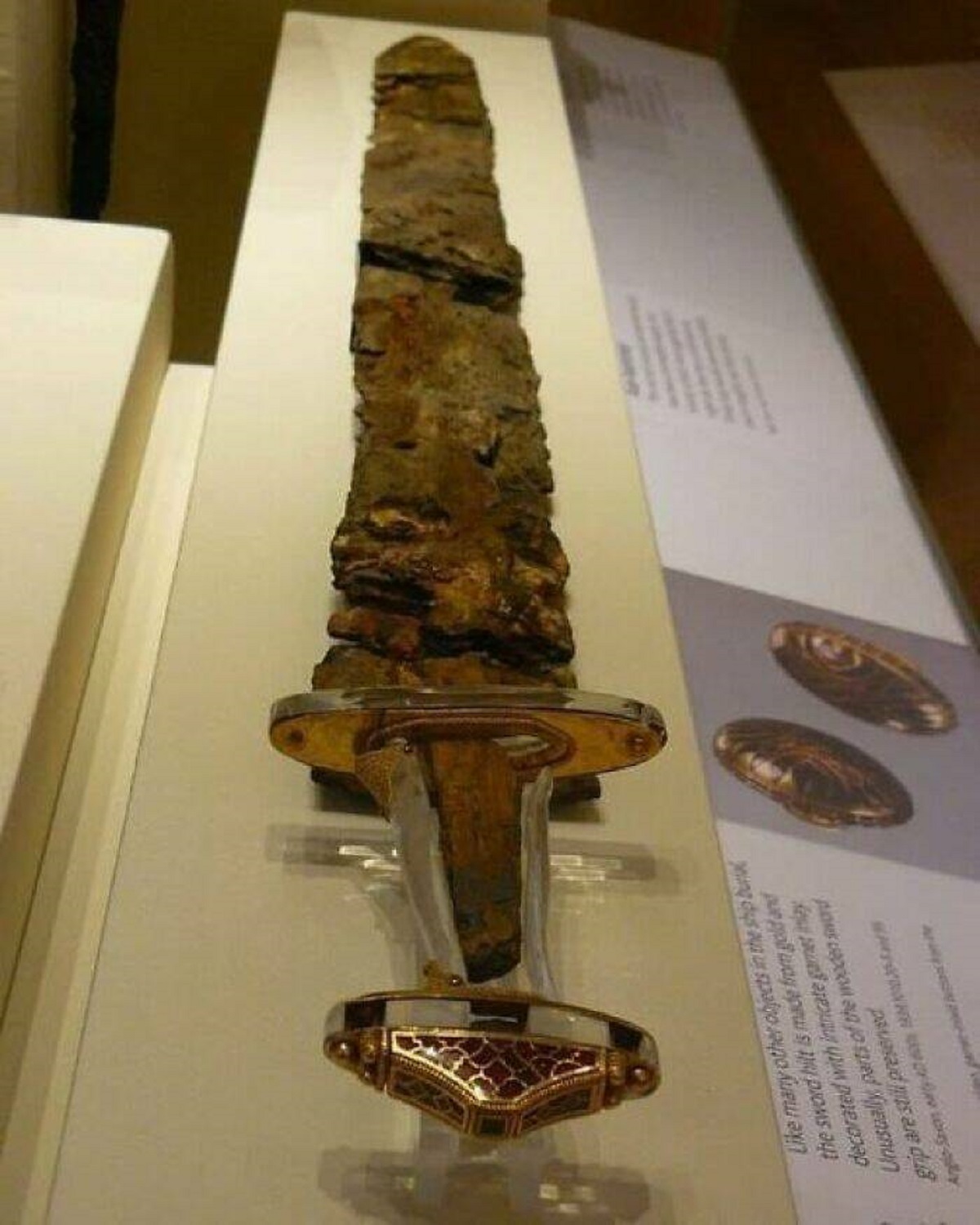 sutton hoo sword - many other objects in the ship bu the sword hilt is made from gold a decorated with intricate gamet inlay Unusually parts of the wooden sword grip are still preserved