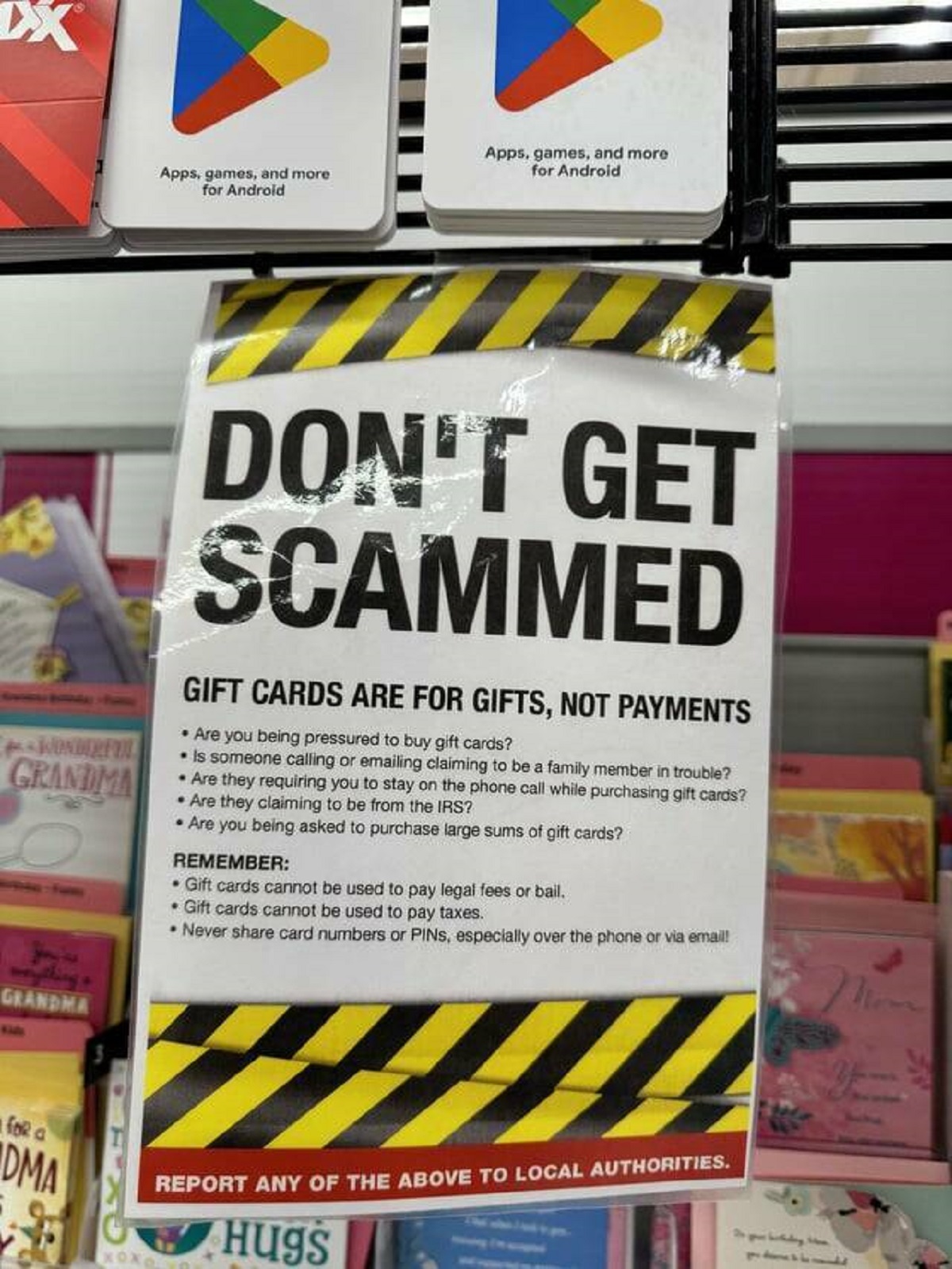 "Grocery store gift card section has a warning against people getting scammed"