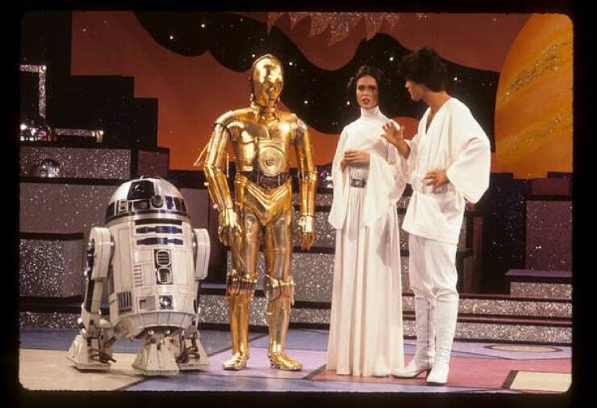 The very first Star Wars spoof was on the Season 3 premiere of the Donny & Marie show in September of 1977 (the film, which opened in May, was still the No. 1 movie in theaters then, and Star Wars mania was in full swing). It featured Donny and Marie as Luke and Leia, Kris Kirstofferson as Han Solo, and Redd Foxx as Obi-Wan Kenobi, and featured dancing Stormtroopers, cheesy jokes, and Chewie hugging Darth Vader: