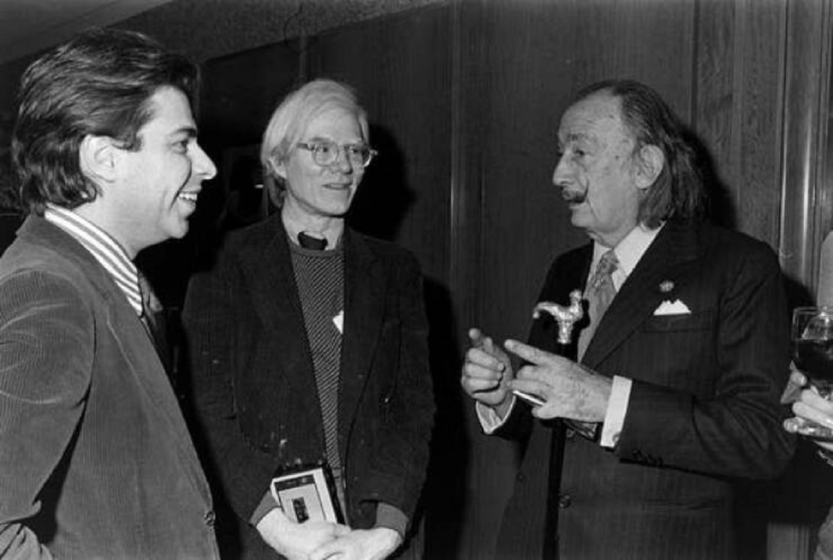 While Salvador Dalí is an artist who is most associated with the surrealism movement of the '20s and '30s, he was actually still a very active artist at the same time Andy Warhol was in the '60s and '70s (in fact, Dalí outlived Warhol). Below is a photo of the two in 1975, at a screening of the film Shampoo: