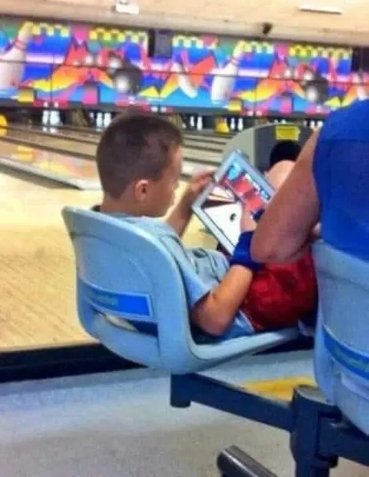 kid playing bowling game at bowling alley