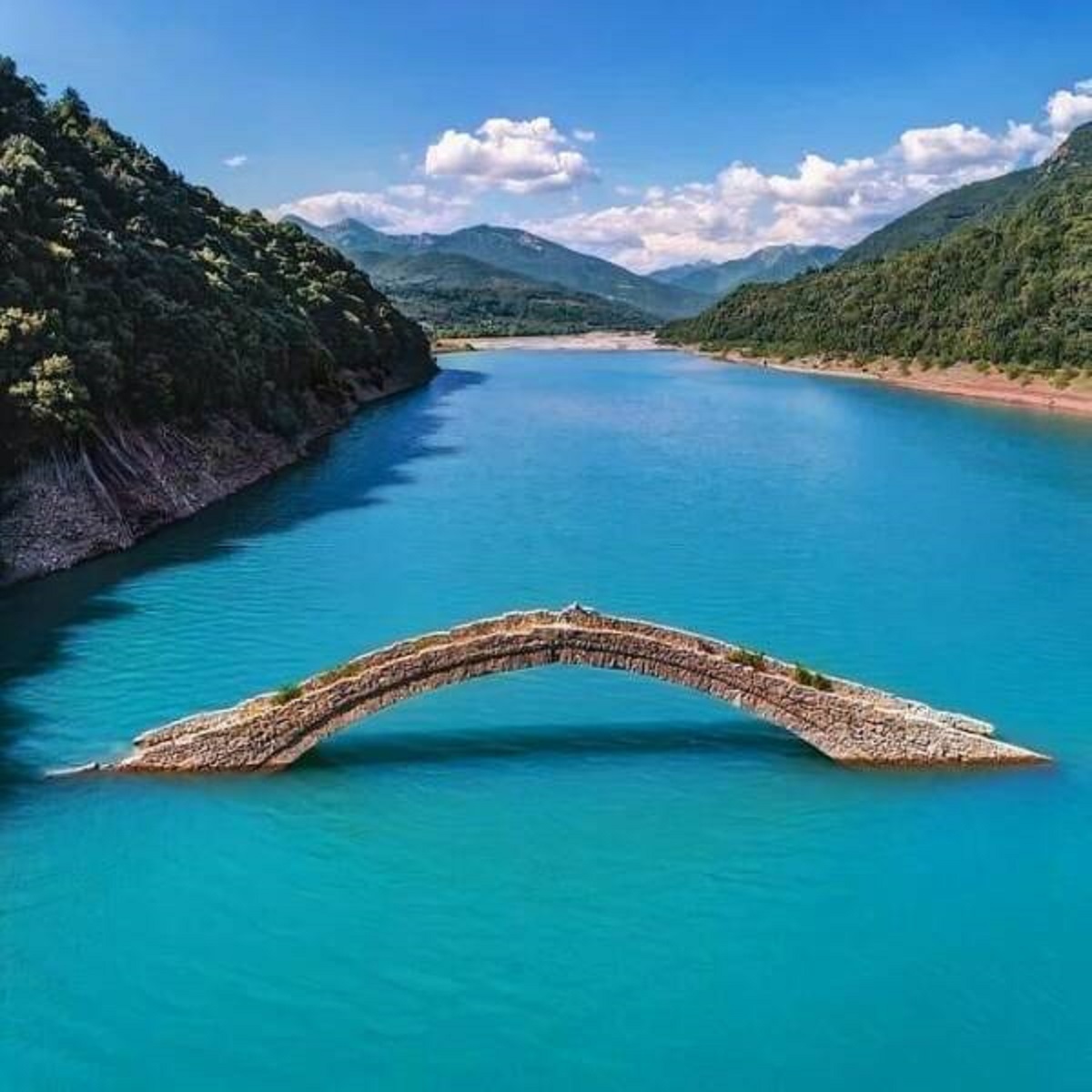 "The Stone Bridge Of Manolis Over Agrafiotis River In Greece. The Bridge Is Almost All Year Underwater And Only Part Of Its Arch May Be Visible, Except The Summer Months When The Water Level Drop"