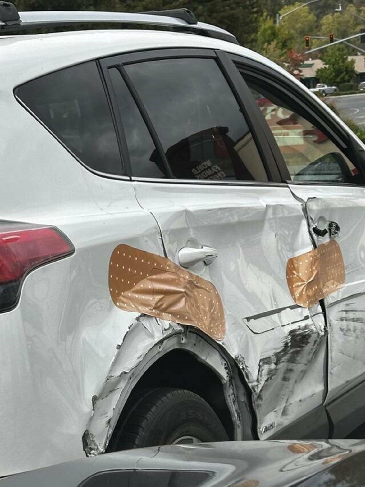 "Giant Band-aid stickers on this smashed up car (OC)"